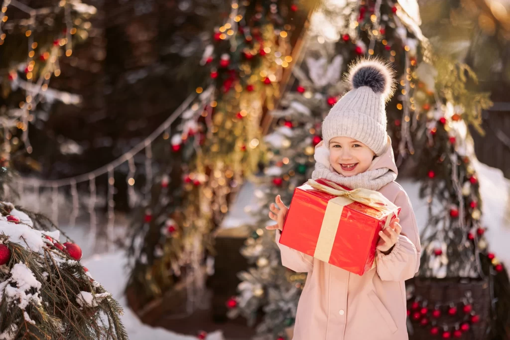 little girl with a christmas gift outdoors in wint 2023 11 27 05 23 09 utc 1024x683 - Boże Narodzenie w Górach – Rodzinna Magia Karkonoszy